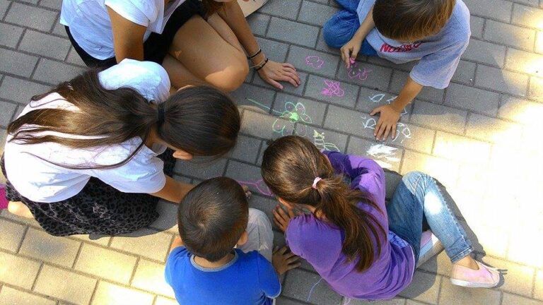 Children drawing on the ground with chalks