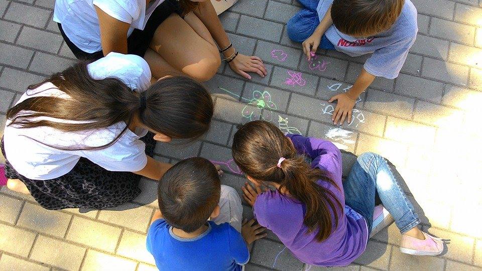 Children drawing on the ground with chalks