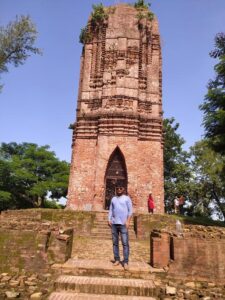 man posing for a picture in front of a temple