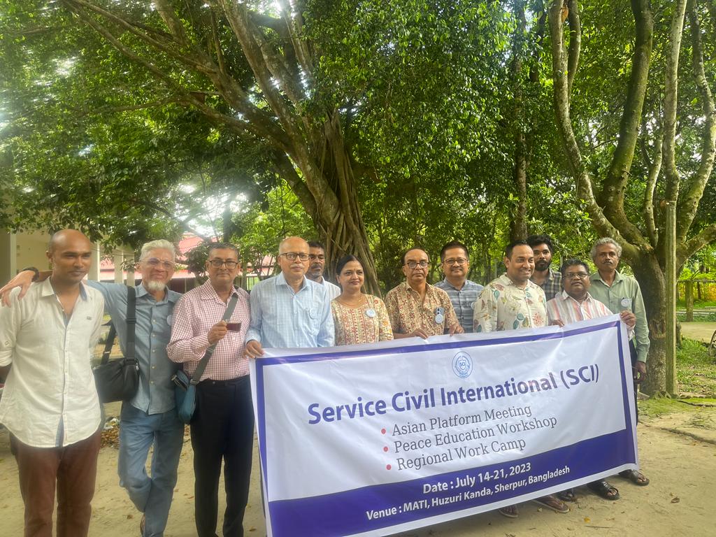 The group of delegates posing with an SCI banner