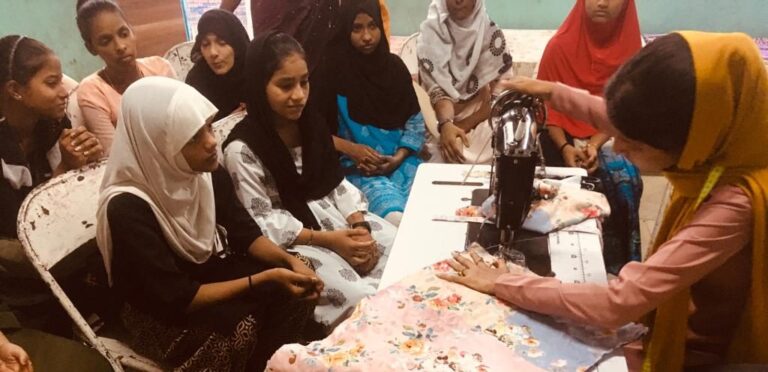 A girls sewing and girls students observing
