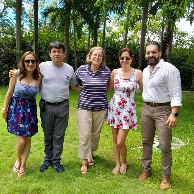 five people posing in a garden