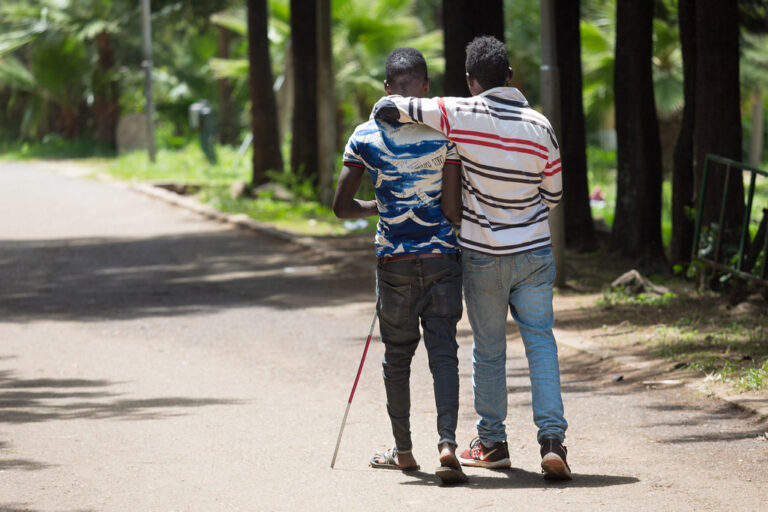 Boy helping his visually impaired friend