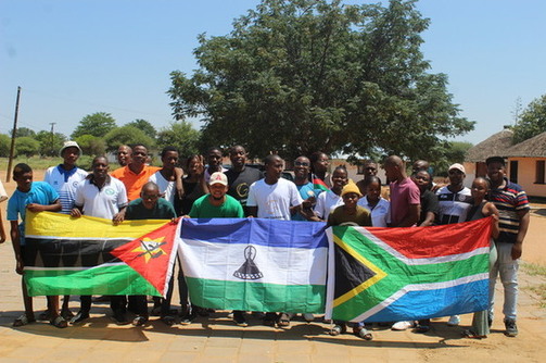 People smiling in group, holding flags