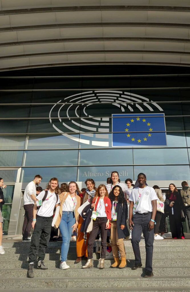 A group of participants in front of the Parliament's entrance