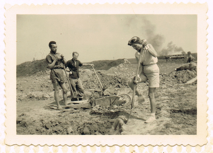 Old picutre of SCI, there is a woman working while some men watch her, proving that she can do the job as easy as the men do